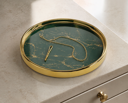 Round dark green and gold vanity tray on a pale dresser with a plain chain and hairpin